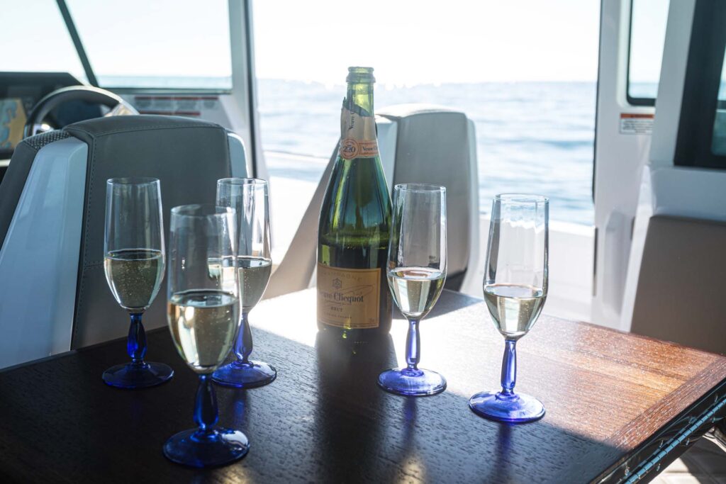 Champagne bottle with glasses on the table of the yacht Calypso