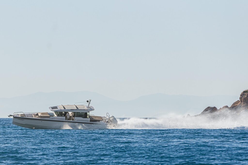 The yacht Calypso speeding with rocky islands in the background