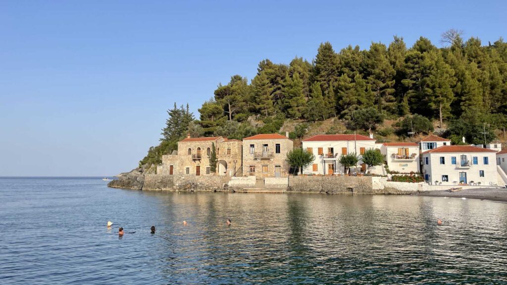 Swimmers with a small seaside village in the background