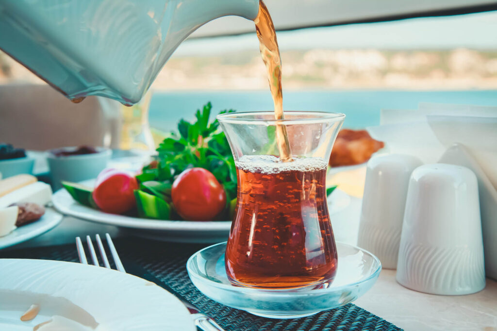 Drink served with salad and cheese and dips in the background