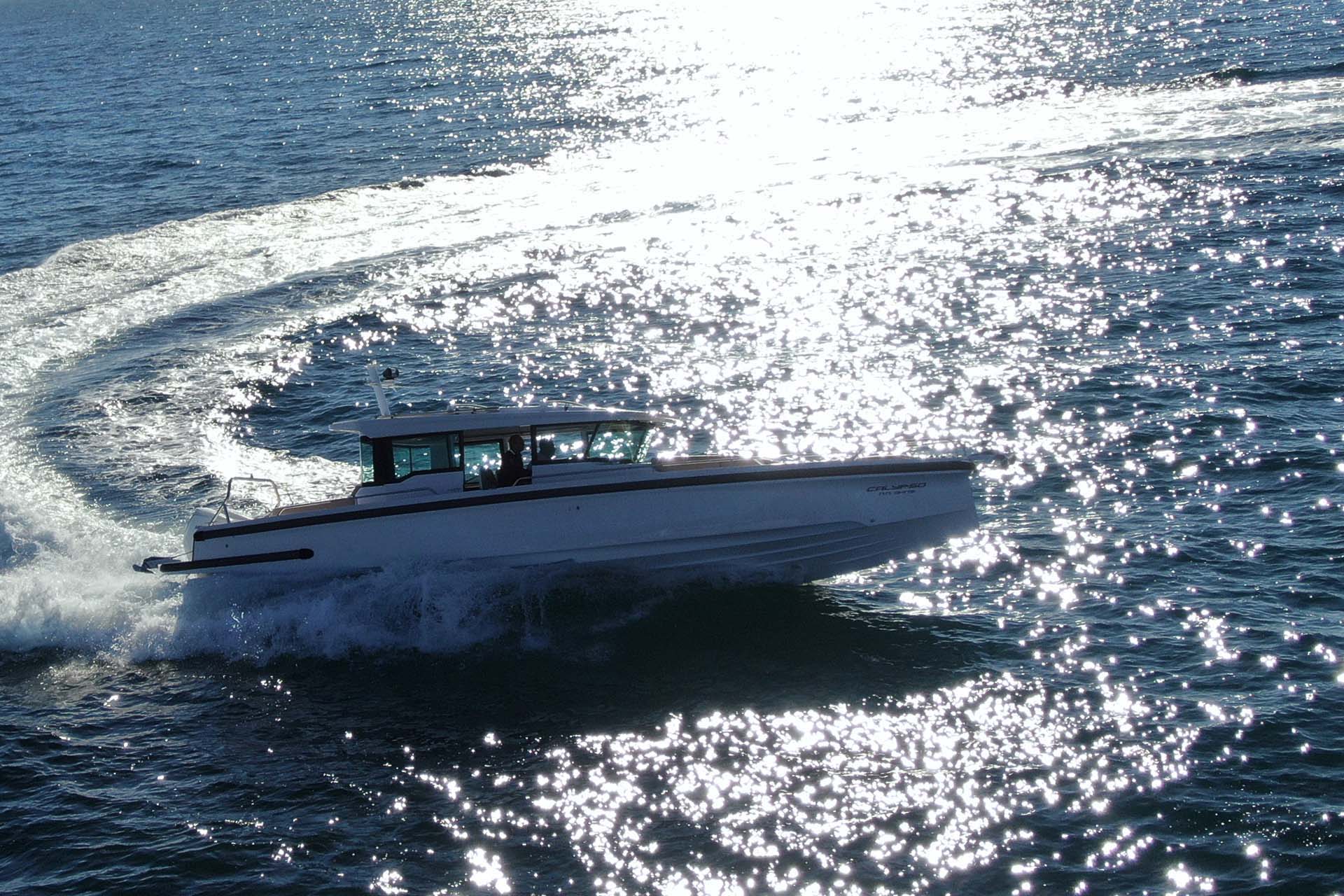 The Yacht Calypso taking a U-turn on the sea reflecting the sun