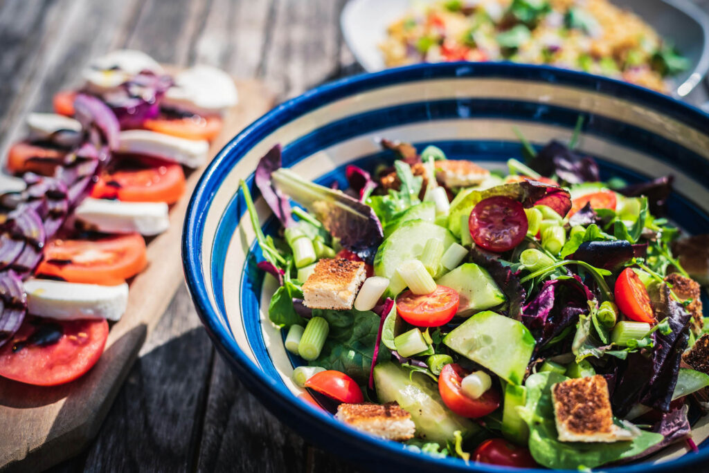 Salad and other dishes on wooden table