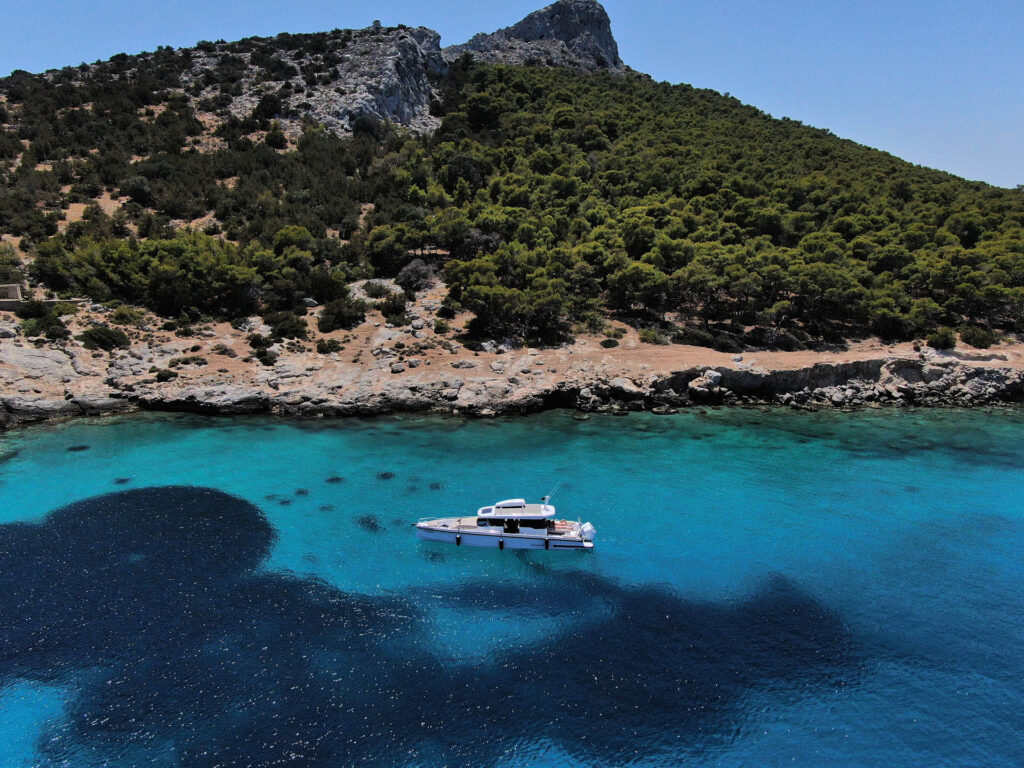 Panoramic view of the Calypso over turquoise waters with hill in the background