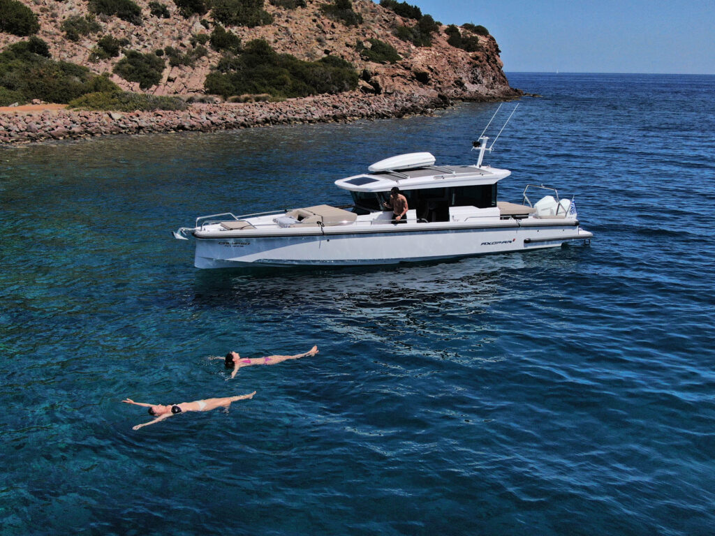 Passengers of the Calypso swimming with rocky island in the background
