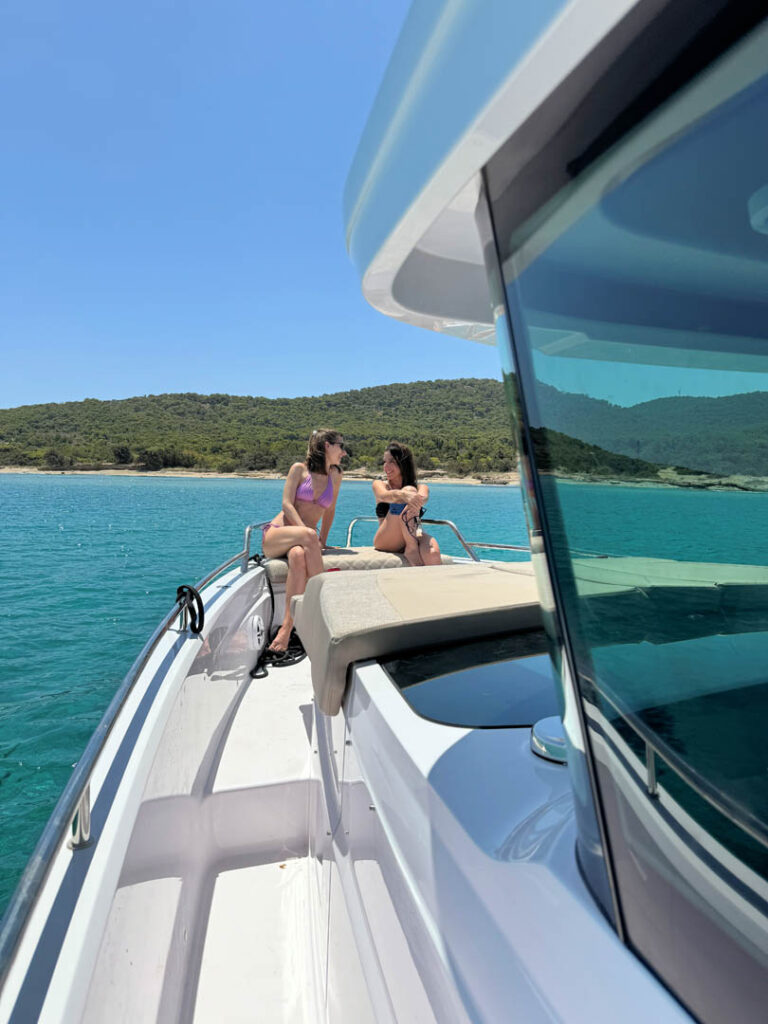 Side view of passengers sitting on the bow of the Calypso yacht